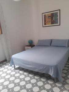 滨海波利尼亚诺Casa Del Parco的卧室内的一张床位,卧室设有白色的墙壁