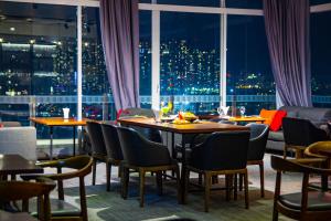 胡志明市胡志明市百艺酒店的餐厅设有桌椅和窗户。