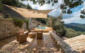 阿查拉维Castelli Olive Press的后院设有游泳池和带遮阳伞的庭院。