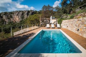 阿查拉维Castelli Olive Press的石头房子前面的游泳池