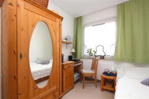 汉诺威Private Room的一间带镜子、一张床和一张书桌的卧室