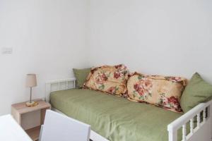 莱乌卡Stella del Mare的客房内的绿色沙发上配有枕头