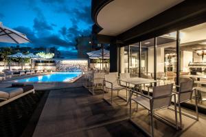 卡拉马塔Garden City Resort的户外庭院设有游泳池和桌椅。