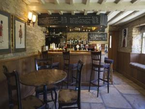 Little FaringdonThe Plough Inn的餐厅内带桌椅的酒吧