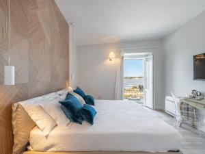 卡洛福泰AQUAMADRE Suites的卧室配有带蓝色枕头的大型白色床
