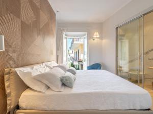 卡洛福泰AQUAMADRE Suites的卧室内的一张带白色床单和枕头的床