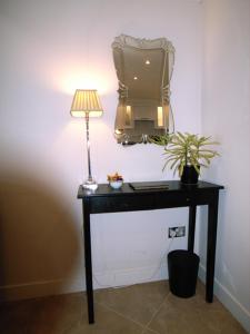 布伦特里Panfield House的一张桌子、一盏灯和一台墙上的电视