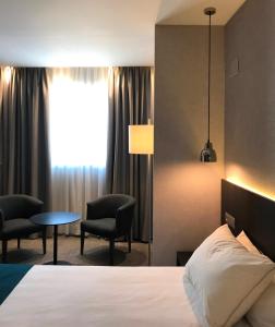 巴塞罗那巴塞罗那HG城市套房酒店的酒店客房带一张床、一张桌子和椅子