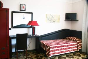 圣乔瓦尼·罗通多加贾诺酒店的一间卧室配有一张床和一张带台灯的书桌