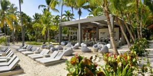 蓬塔卡纳蓬塔卡纳加泰罗尼亚全包酒店的海滩上设有白色躺椅和棕榈树