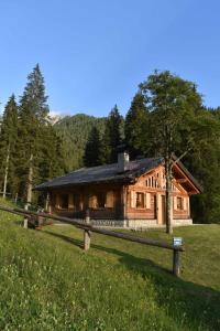 摩德纳迪-坎皮格里奥Chalet Brenta Dolomites的小木屋前方设有围栏