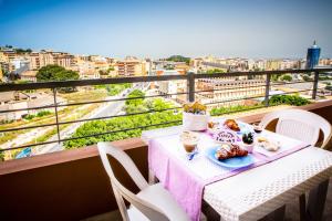 卡利亚里A View on Cagliari的阳台上的餐桌上放着一盘食物