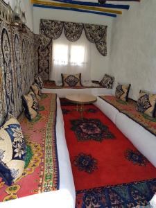 MelaahMaison d'hôtes "Abou-Hachem"的带沙发和红色地毯的客厅