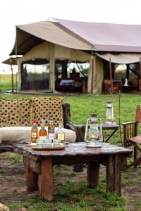 巴纳吉Pumzika Luxury Safari Camp的一张木桌,上面装有酒瓶