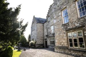 BodelwyddanFaenol Fawr Country Hotel的一座古老的石头建筑,设有大窗户