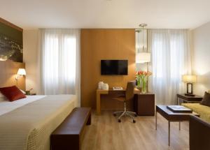 米兰星际利兹酒店的配有一张床和一张书桌的酒店客房