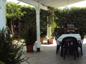 拉卡莱VILLA ROBERTO VICINO GALLIPOLI的庭院配有桌椅和植物