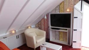 登堡Noordwester 45的一间带电视和椅子的客厅