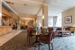 哈罗盖特斯特拉斯莫尔石堆纪念碑酒店的酒店大堂设有椅子和桌子