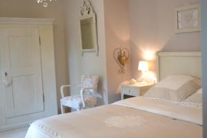 普洛布塞姆库尔安格莱斯度假屋的白色卧室配有床和椅子