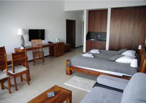 波莫瑞地区德拉夫斯科M Club Hotel | Lubie Resort的一间卧室配有一张床、一张沙发和一张桌子
