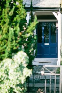 温德米尔布雷芒特别墅住宿加早餐酒店的带有栅栏的房子上的一扇蓝色门