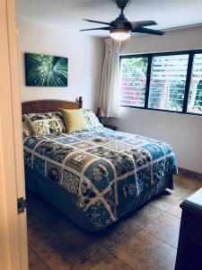 基黑Aloha WAI的一间卧室配有一张床和吊扇