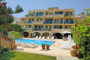 赫索尼索斯佩特拉海滩酒店的一座带游泳池和大楼的酒店