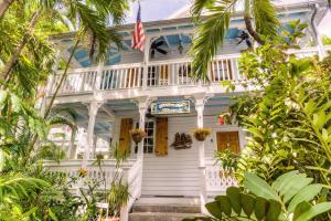 基韦斯特Key West Harbor Inn - Adults Only的一座白色的房子,上面有美国国旗