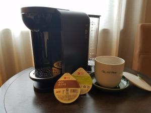 高冈市高冈新大谷酒店的咖啡壶和茶几上的咖啡杯
