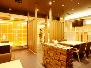 高冈市高冈新大谷酒店的一间带桌椅和柜台的餐厅