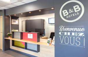 尚贝里B&B HOTEL CHAMBERY La Cassine的带有接待台的bb抵押办公室的标志