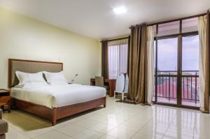 金贾Igar Plaza Hotel的一间卧室设有一张床和一个大窗户