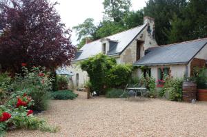 BrionLe Logis du Pressoir Chambre d'Hotes Bed & Breakfast in beautiful 18th Century Estate in the heart of the Loire Valley with heated pool and extensive grounds的庭院里带花卉的花园的房子