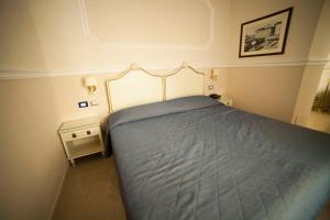 利沃诺葛兰杜卡酒店的一间卧室配有一张带蓝色棉被的床