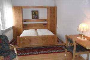 奥特贝格巴德司徒贝酒店的一间卧室配有一张带书桌和桌子的四柱床。