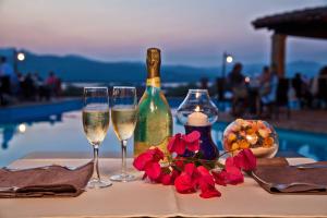 罗通多港Residence Stella Di Gallura的一张桌子,上面放着两杯葡萄酒和鲜花