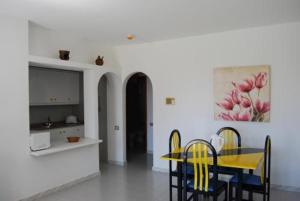 科斯塔特吉塞莫林诺德瓜提萨酒店的用餐室配有黄色的桌子和椅子