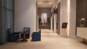 宿务Khalil's Horizons 101 Studio Type Condominium的大楼内带蓝色椅子和桌子的走廊