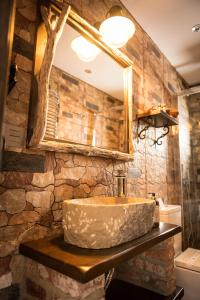 索托德尔瓦尔科Hotel Tejera del Nalon的石质浴室设有水槽和镜子