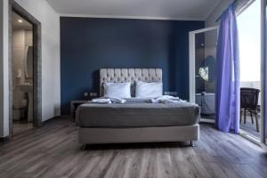 蒂锡利维Zante Calinica Hotel的一间卧室配有一张蓝色墙壁和木地板。