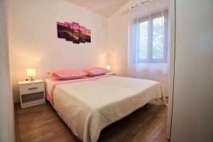 内乌姆Villa Nada的一间卧室配有带粉红色枕头的床和窗户。
