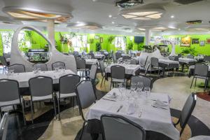 圣克鲁斯德穆德拉Hotel Restaurante Santa Cruz的一间设有白色桌椅和绿色墙壁的用餐室