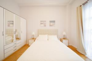 希洪Balcon al Cantabrico的白色的卧室设有一张白色大床和一个窗户。