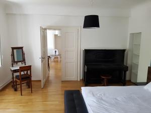 卢布尔雅那SIPPO Apartments的卧室配有床、书桌和钢琴