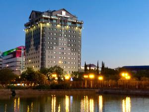 塞维利亚塞维利亚中心酒店的水体前有灯的大建筑