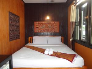 清孔Baanfai Guesthouse Chiangkhong的一间卧室配有一张床,上面有两条毛巾