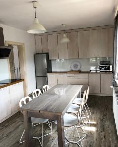 什恰夫尼察Carlina House的厨房配有木桌和白色椅子