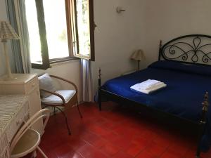陶尔米纳Villa Mariedda的一间卧室配有蓝色的床和椅子