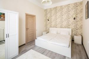 利沃夫#1 APARTMENT的卧室配有白色的床和墙壁